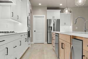 Kitchen with recessed lighting, light countertops, stainless steel appliances, decorative backsplash, and custom range hood