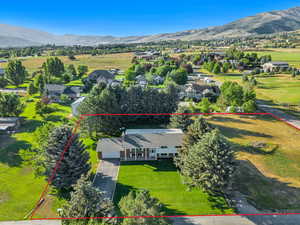 Aerial perspective of suburban area featuring property boundaries highlighted and mountains