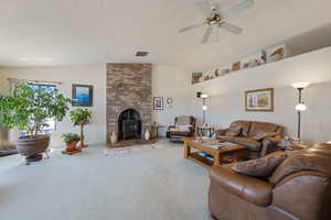 Living room with vaulted ceiling, a wood stove, carpet floors, and ceiling fan