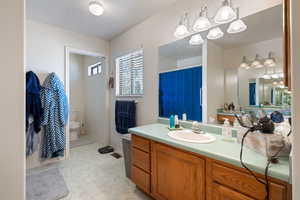 Bathroom featuring a chandelier, vanity, marble finish floors, and a shower with curtain