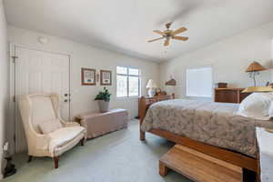 Carpeted bedroom featuring ceiling fan