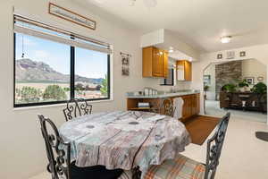 Dining room featuring light colored carpet, healthy amount of natural light, ceiling fan, and a mountain view