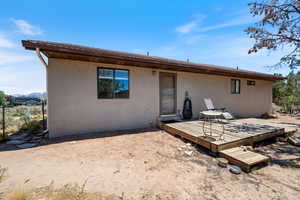 Rear view of house with stucco siding and a deck