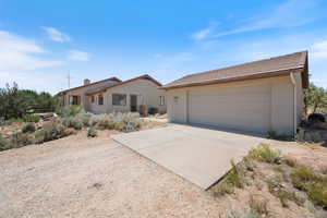 Ranch-style home featuring a garage, stucco siding, and driveway