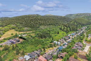 View of property location featuring a heavily wooded area and nearby suburban area