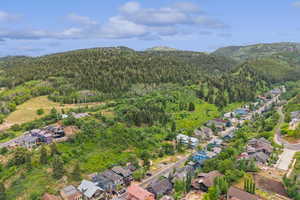 View of property location with a forest and nearby suburban area