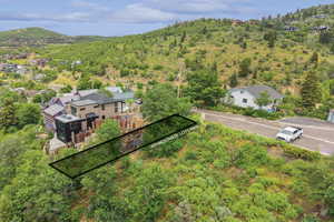 Aerial view of property and surrounding area featuring property parcel outlined and mountains