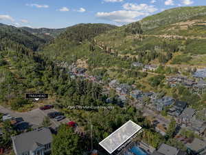 Aerial overview of property's location with a mountainous background and nearby suburban area
