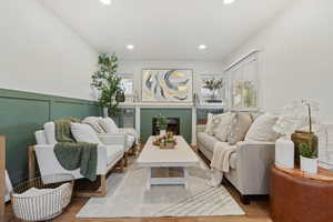 Living area with wood finished floors, recessed lighting, and a fireplace