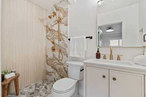 Full bathroom with vanity and a marble finish shower