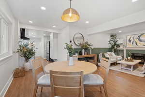 Dining space featuring wood finished floors, recessed lighting, and a fireplace