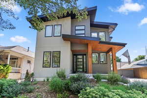 Modern home featuring covered porch and stucco siding