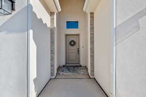 Property entrance with stone siding and stucco siding