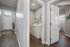 Washroom featuring washer and clothes dryer and dark wood-style floors