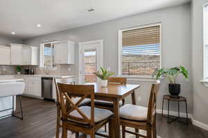 Dining space with dark wood-type flooring and recessed lighting