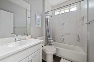 Bathroom with vanity, shower / bath combo with shower curtain, and wood finished floors