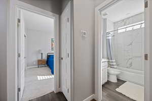 Full bath with wood finished floors, shower / bathtub combination with curtain, and vanity