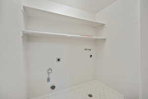 Laundry room with hookup for an electric dryer, tile patterned flooring, hookup for a gas dryer, and hookup for a washing machine