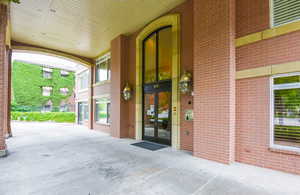 View of exterior entry with brick siding