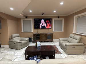 Living area with crown molding, arched walkways, and recessed lighting