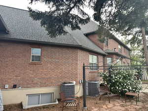 Rear view of house featuring brick siding, a patio area, and a high end roof