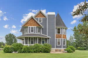 View of front of home featuring a front lawn, a shingled roof, and a chimney
