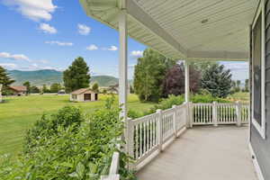 Porch with a mountain view and a lawn