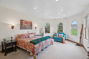 Carpeted bedroom with multiple windows and recessed lighting