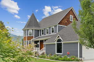 View of front facade featuring roof with shingles, a mountain view, and an attached garage