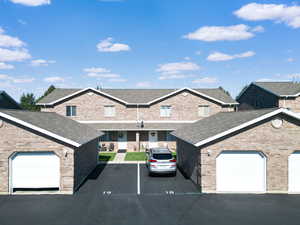 View of front of property with brick siding and a shingled roof