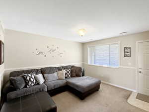 Living area featuring light colored carpet and a textured ceiling