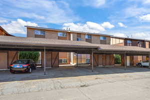 Townhome / multi-family property with brick siding and covered parking