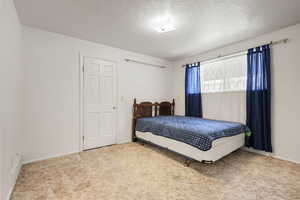 Bedroom featuring carpet flooring and a textured ceiling