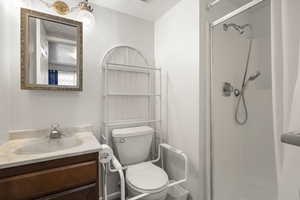 Bathroom with a walk in shower, vanity, and a textured ceiling