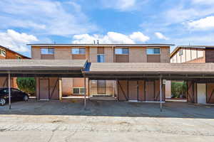View of front of property with brick siding and covered parking