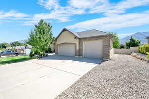 View of front of property with a mountain view, a garage, concrete driveway, stucco siding, and a shingled roof