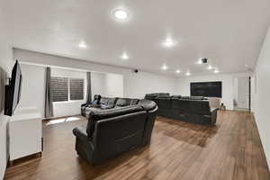 Living area featuring dark wood-style flooring and recessed lighting