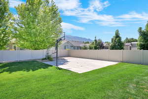 Fenced backyard with a mountain view and basketball court