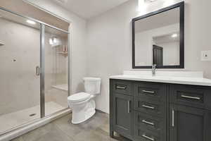 Bathroom featuring vanity, a shower stall, and tile patterned floors