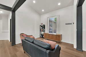 Living area featuring wood finished floors, recessed lighting, and vaulted ceiling