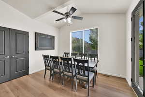 Dining room featuring healthy amount of natural light, light wood-style flooring, lofted ceiling, and a ceiling fan