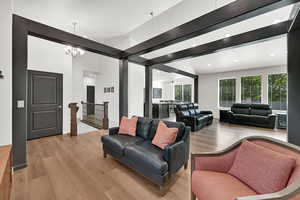 Living room featuring light wood finished floors, a chandelier, and recessed lighting