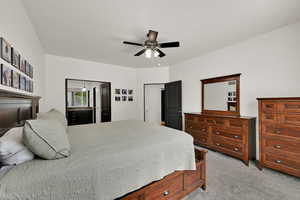 Bedroom with light colored carpet and a ceiling fan