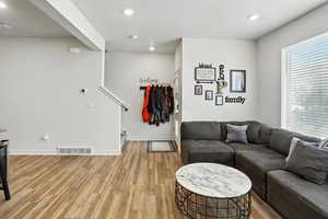 Living area with stairway, new light wood-style LVP floors, and recessed lighting