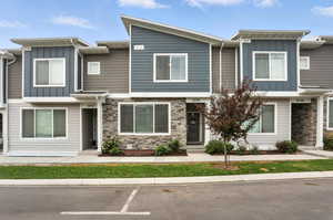 Townhome featuring board and batten siding and stone siding