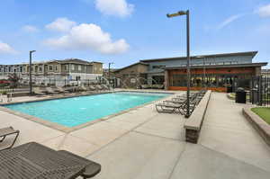 Community pool with a patio area and a residential view and clubhouse
