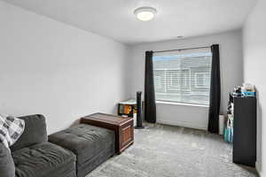 Bedroom featuring light carpet and a textured ceiling