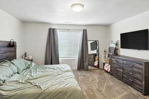 Primary Bedroom featuring light carpet and a textured ceiling