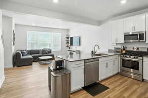 Kitchen with stainless steel appliances, a peninsula, open floor plan, recessed lighting, and new light wood-style LVP floors