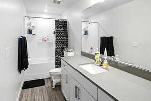 Full private bath featuring wood-style LVP floors, vanity, and shower / bath combination with curtain